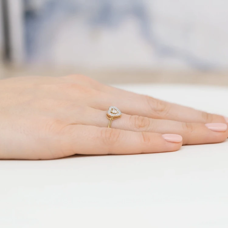 Złoty pierścionek serduszko z diamentami, prezentowany na dłoni produktu W0442.Z3.DIW.01