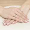 Delikatny pierścionek z białego złota z pojedynczym brylantem, prezentowany na dłoni produktu W0471.B3.DIW.01