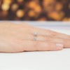 Elegancki pierścionek z białego złota z brylantem w kształcie róży, prezentowany na dłoni na jasnym, rozmazanym tle produktu P027-B585-B0.10