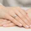 Elegancki pierścionek z białego złota z centralnym brylantem o masie 0,40 ct oraz otoczką z 28 brylancików, prezentowany na dłoni produktu W0551.B3.DIW.01
