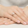 Wykwintny pierścionek z różowego złota z centralnym brylantem o masie 0,70ct, otoczonym przez 26 bocznych brylantów, prezentowany na dłoni z paznokciami w kolorze pudrowego różu, produktu W0551.R3.DIW.03