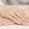 Okrągły pierścionek z białego złota z brylantem w stylu halo, otoczony mniejszymi kamieniami, prezentowany na dłoni produktu W0508.B3.DIW.01