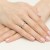 Elegancki pierścionek z białego złota z centralnie osadzonym brylantem, prezentowany na dłoni z subtelnym różowym manicure, produktu W0539.B3.DIW.02