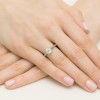 Ażurowy pierścionek z białego złota z centralnie osadzonym brylantem o masie 1,00ct, prezentowany na dłoni z paznokciami w kolorze jasnoróżowym produktu W0542.B3.DIW.04