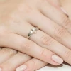 Elegancki pierścionek zaręczynowy z białego złota z brylantem o szlifie klasycznym, prezentowany na dłoni z subtelnym manicure w odcieniu nude, produktu W0155.B3.DIW.01