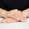 Pierścionek zaręczynowy z białego złota z trzema brylantami osadzonymi na wąskiej obrączce, prezentowany na dłoni na jasnym tle produktu W0344.B3.DIW.01