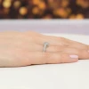 Wyrazisty pierścionek z białego złota z wieloma brylantami otaczającymi centralny kamień, prezentowany na dłoni z manicure w kolorze pudrowego różu, produktu W0530.B3.DIW.01
