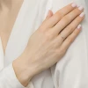 Delikatny, złoty pierścionek z dwoma drobnymi kamieniami – jednym niebieskim i jednym białym – osadzonymi na cienkiej obrączce, prezentowany na dłoni produktu EP144-333-NB