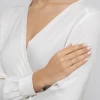 Delikatny złoty pierścionek z prostokątną białą cyrkonią, noszony na palcu modelki ubranej w białą bluzkę produktu EP170-333-B