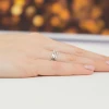 Elegancka biała złota obrączka z brylantami, z dwoma rzędami drobnych kamieni szlifowanych brylantowo, prezentowana na dłoni produktu W0612.B3.DIW.01