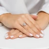 Elegancki pierścionek z białego złota wysadzany licznymi brylantami, prezentowany na dłoni z białym manicure produktu W0570.B3.DIW.01