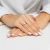 Elegancki pierścionek z żółtego złota z prostokątnym morganitem otoczonym błyszczącymi cyrkoniami, prezentowany na dłoni z białym manicure, produktu W0575.Z3.MOP.01