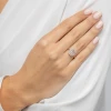 Elegancki pierścionek z różowego złota z prostokątnym, bladokremowym morganitem otoczonym aureolą drobnych białych kamieni, prezentowany na dłoni produktu W0576.R3.MOP.01
