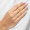 Delikatny złoty pierścionek wysadzany białymi cyrkoniami, prezentowany na dłoni z wykonanym manicure francuskim produktu EP174-333-B