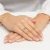 Złoty pierścionek z granatowym kamieniem centralnym i białymi cyrkoniami, prezentowany na dłoni z różowym manicure produktu P180-333-G
