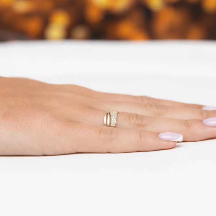 Złoty pierścionek zaręczynowy z wieloma drobnymi cyrkoniami, prezentowany na białym tle na kobiecej dłoni z delikatnym manicurem produktu P175-333-B