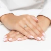 Złoty pierścionek z kwadratową koroną wysadzaną cyrkoniami prezentowany na dłoni z paznokciami w stylizacji french manicure na białym tle produktu AP143-585-B