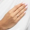 Delikatny pierścionek z żółtego złota z kwadratowym brylantem princessa, prezentowany na kobiecej dłoni na tle białej tkaniny produktu W0586.Z3.DIW.01