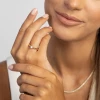 Delikatny, złoty pierścionek zaręczynowy z pojedynczym, lśniącym diamentem laboratoryjnym prezentowany na dłoni modelki produktu W0229.Z3.LDW.07
