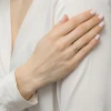 Delikatny złoty pierścionek z małą cyrkonią, prezentowany na dłoni ubranej w białą koszulę, produktu EP153-585