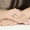 Elegancki pierścionek zaręczynowy z białego złota wysadzany brylantami, prezentowany na dłoni z jasnym manicure, produktu W0023.B3.DIW.01