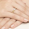 Delikatny pierścionek z żółtego złota z pojedynczym, okrągłym diamentem laboratoryjnym osadzonym na smukłej obrączce, prezentowany na dłoni produktu W0225.Z3.LDW.05