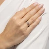 Delikatny pierścionek z białego złota w kształcie kwiatuszka wysadzanego błyszczącymi diamentami, prezentowany na dłoni produktu W0627.B3.DIW.01
