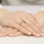 Klasyczny pierścionek z białego złota z pojedynczym brylantem osadzonym na eleganckiej obrączce, prezentowany na dłoni z paznokciami w pastelowym różu produktu W0220.B3.DIW.07