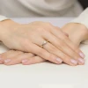Delikatny złoty pierścionek z pojedynczym, błyszczącym diamentem laboratoryjnym na subtelnej obrączce, prezentowany na dłoni produktu W0562.Z3.LDW.01