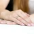 Klasyczny pierścionek zaręczynowy z białego złota z brylantem, prezentowany na dłoni z delikatnie różowym manicure produktu W0267.B3.DIW.02
