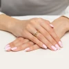 Złoty pierścionek z motywem podwójnych ogniw wysadzanych cyrkoniami, prezentowany na dłoni z delikatnym manicure, produktu P-GW-031-585