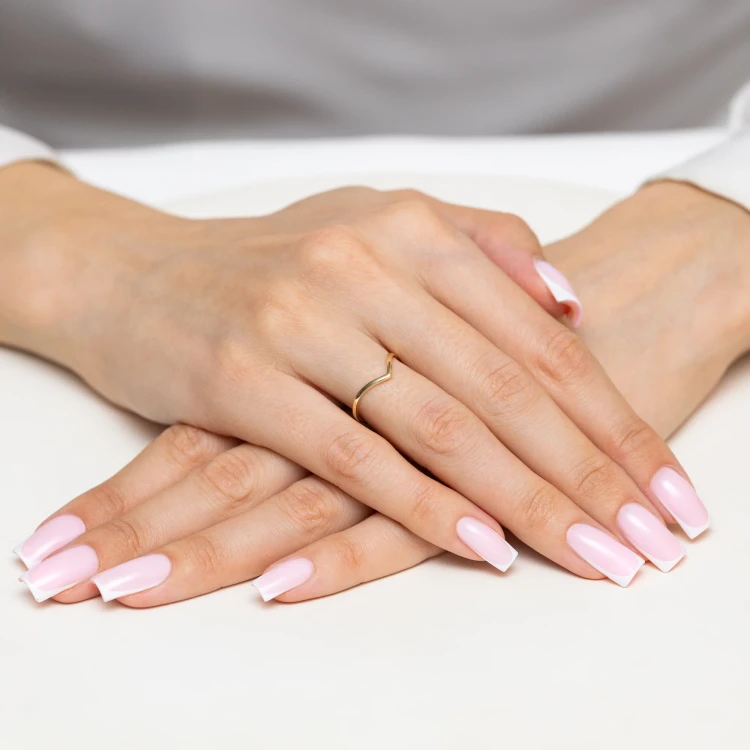 Delikatny złoty pierścionek o kształcie fali V, prezentowany na dłoni z paznokciami w stylu francuskiego manicure produktu AP230-333
