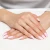Złoty pleciony pierścionek skręcana obrączka bez kamieni szlachetnych, prezentowany na dłoni z paznokciami w stylu francuskiego manicure produktu AP229-333