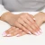 Złoty pierścionek w kształcie serca wysadzany małymi cyrkoniami, prezentowany na dłoni z wykonanym manicure francuskim, produktu AP227-333-B