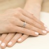 Elegancki pierścionek z białego złota z jednym brylantem, prezentowany na dłoni produktu P039-B585-B0.15
