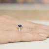 Złoty pierścionek zaręczynowy z szafirem i diamentami Dynastia, prezentowany na dłoni produktu W0330.Z3.SAB.01