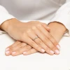 Ażurowy pierścionek z białego złota z subtelnym diamentem, prezentowany na dłoniach z delikatnym manicurem, produktu W0708.B3.DIW.01