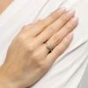 Złoty pierścionek w kształcie koniczynki, wysadzany brylantami, prezentowany na dłoni modelki produktu W0696.Z3.DIW.01