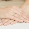Złoty pierścionek zaręczynowy z owalnym diamentem laboratoryjnym i dodatkowymi brylantami, prezentowany na dłoni produktu W0308.Z3.LDW.01
