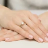 Złoty pierścionek z okrągłym diamentem laboratoryjnym o masie 1,00 ct, osadzony na delikatnej obrączce z żółtego złota, prezentowany na dłoni z paznokciami w kolorze pudrowego różu, produkt W0547.Z3.LDW.04.