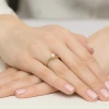 Delikatny złoty pierścionek z błyszczącym diamentem laboratoryjnym na delikatnej obrączce, prezentowany na dłoni produktu W0547.Z3.LDW.01