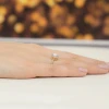 Okazały złoty pierścionek z białym szafirem i diamentami kwadratowa korona Dynastia, prezentowany na dłoni produktu W0514.Z3.SAW.01
