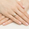 Delikatny żółty pierścionek z pojedynczym, okrągłym diamentem laboratoryjnym na minimalistycznej obrączce, prezentowany na dłoni produktu W0542.Z3.LDW.03