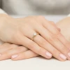 Delikatny pierścionek z żółtego złota z centralnie osadzonym diamentem laboratoryjnym oraz kamieniami wokół korony, prezentowany na dłoni produktu W0539.Z3.LDW.01