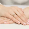 Elegancki pierścionek z żółtego złota z okazałym diamentem laboratoryjnym na półokrągłej szynie, prezentowany na dłoni produktu W0553.Z3.LDW.04
