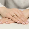 Delikatny pierścionek z żółtego złota z błyszczącym diamentem laboratoryjnym o okrągłym szlifie, prezentowany na dłoni kobiety z paznokciami pomalowanymi na jasnoróżowy kolor produktu W0544.Z3.LDW.02