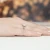 Złoty pierścionek z owalnym diamentem laboratoryjnym w otoczeniu brylantów, prezentowany na dłoni z dopasowanym manicure produktu W0182.Z3.LDW.01