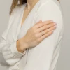 Delikatny złoty pierścionek obrączka z licznymi drobnymi brylantami, prezentowany na dłoni z subtelnym manicure, produktu P142-585-B0.09