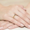Złoty pierścionek z granatowym kamieniem z kolekcji Klasyka, prezentowany na dłoni z pastelowym manicure produktu W0222.Z3.SAB.02