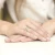 Białe złoto stanowi obrączkę pierścionka z delikatnie osadzonym brylantem w kształcie serca, prezentowanego na dłoni z manicure w kolorze nude, produktu W0071.B3.DIW.01